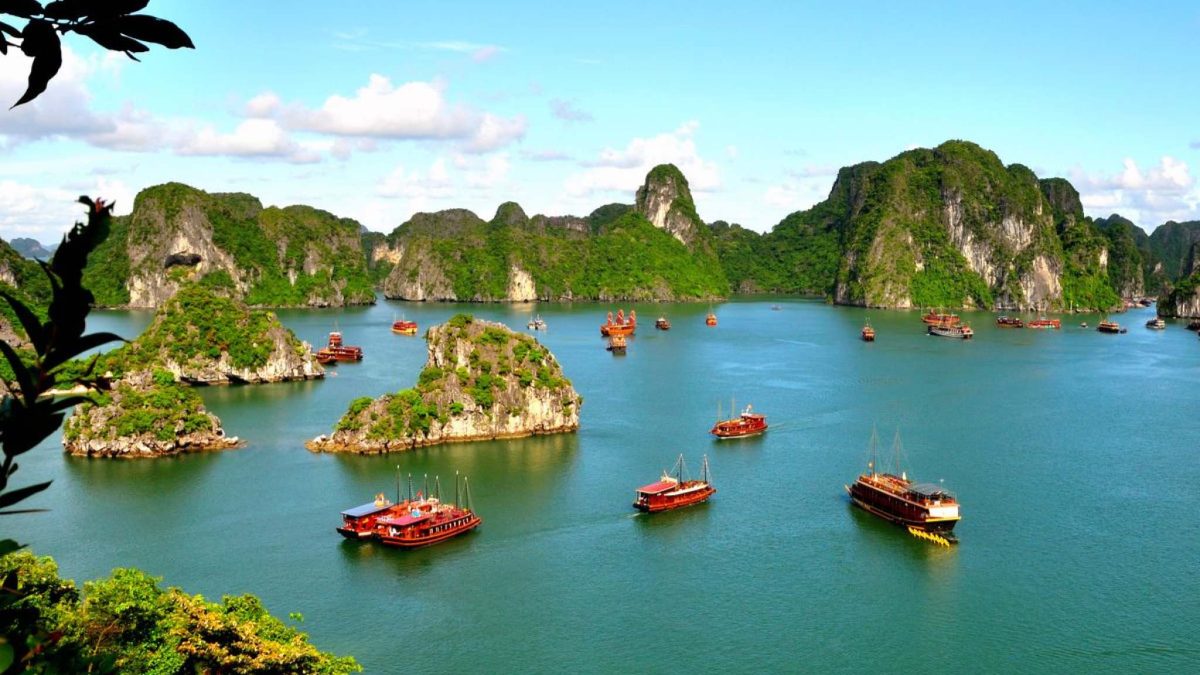 Traditional junk boats sailing among the limestone karsts of Halong Bay, Vietnam