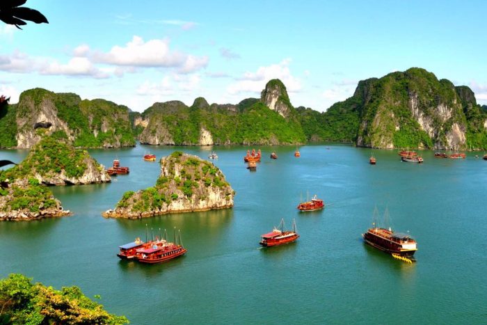 Traditional junk boats sailing among the limestone karsts of Halong Bay, Vietnam