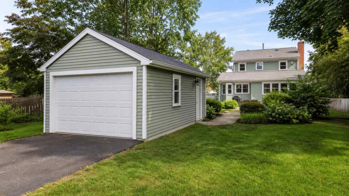 A standalone detached garage beside a suburban home