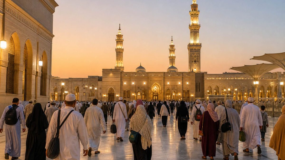 Pilgrims walking through an illuminated mosque courtyard at dusk during Umrah travel
